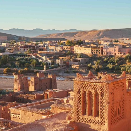 From above old town with stone constructions near narrow river between desert and beautiful heaven with clouds in Marrakesh, Morocco